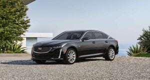 A black 2022 Cadillac CT5 parked near a modern home.