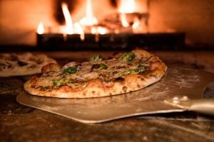 Pizza inside an open fire pizza oven.