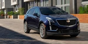 A dark blue Cadillac XT5 in the alley of townhomes.
