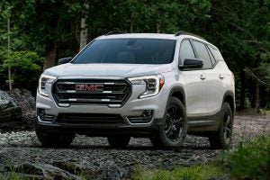 White 2022 GMC Terrain parked on gravel in the woods.