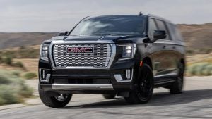 A black 2022 GMC Yukon XL Delani driving on the highway surrounded by the desert. 