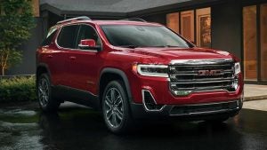 Red 2022 GMC Acadia parked in front of a house.