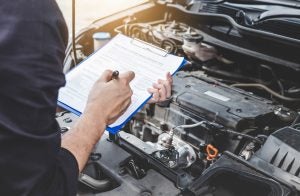 Man with clipboard inspecting car | Frederick, MD