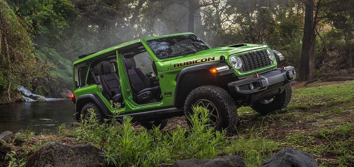 Lime green 2026 Jeep Wrangler Rubicon four door with doors removed exiting a stream