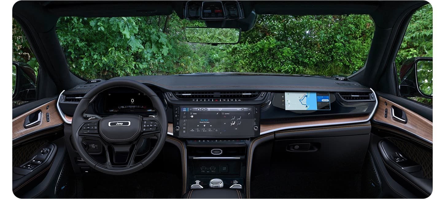 Front seat area and Uconnect touchscreen in a 2026 Jeep Grand Cherokee Summit