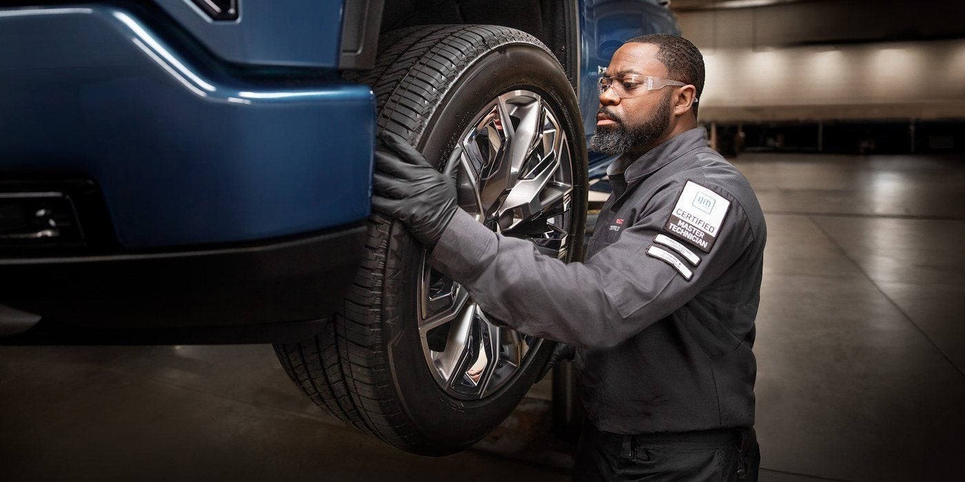 Technician changing a tire at the Holiday CDJR service department in Graham