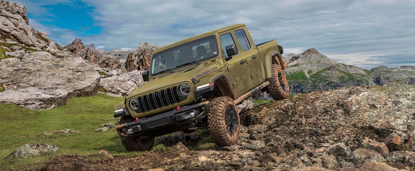 Olive green 2026 Jeep Gladiator Rubicon X descending a rocky off road trail