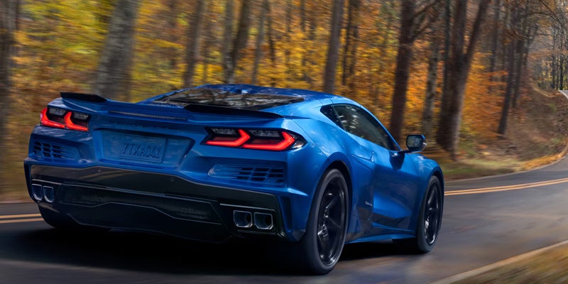 A 2026 Chevrolet Corvette ZR1 drives down a tree-lined road in fall, showcasing vibrant autumn foliage in Bakersfield, CA.