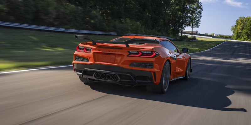 Rear view of an orange 2020 Chevrolet Corvette parked in Bakersfield, CA, showcasing its sleek design and sporty features.