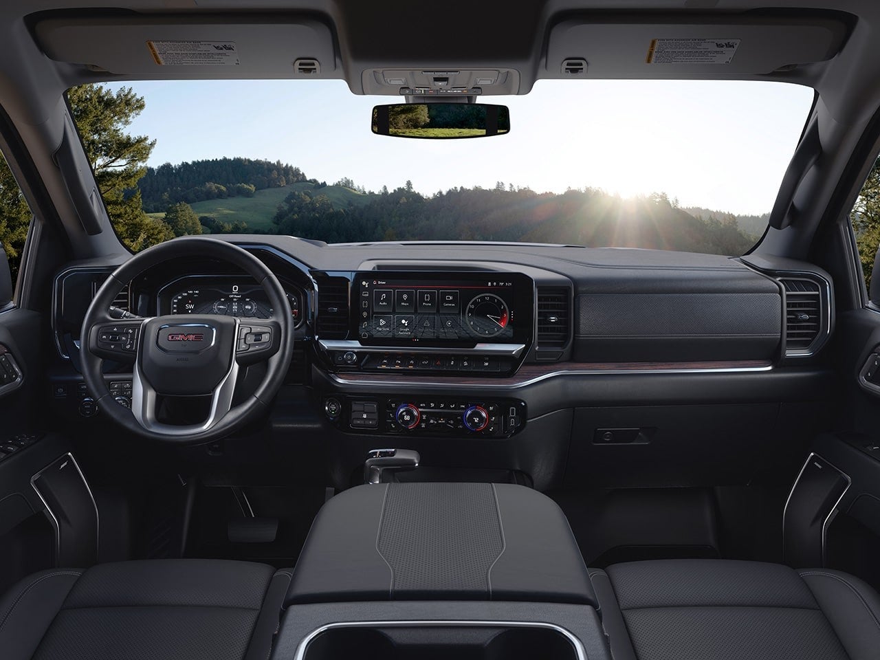 Interior of a GMC Sierra 1500 showing the front seats, steering wheel and digital dashboard