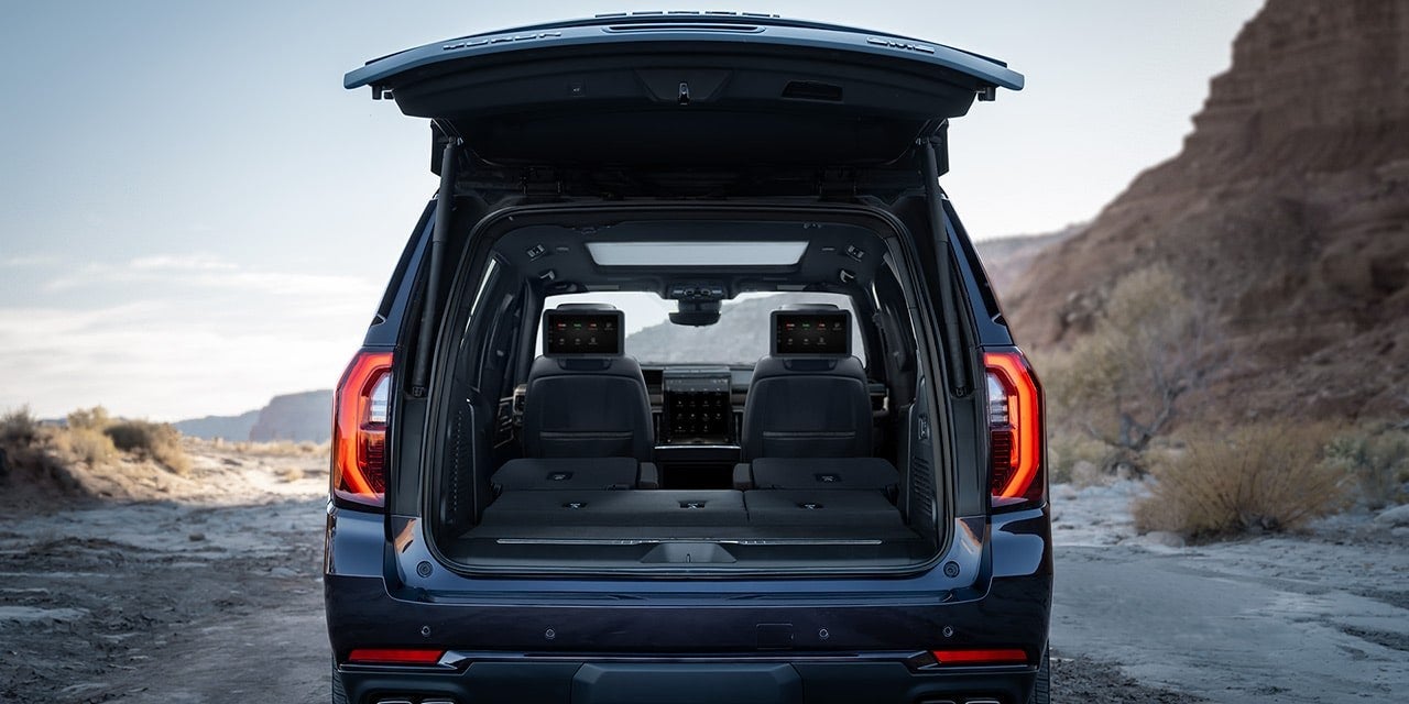 Rear of a GMC Yukon with the tailgate open showing cargo space for lake weekend gear