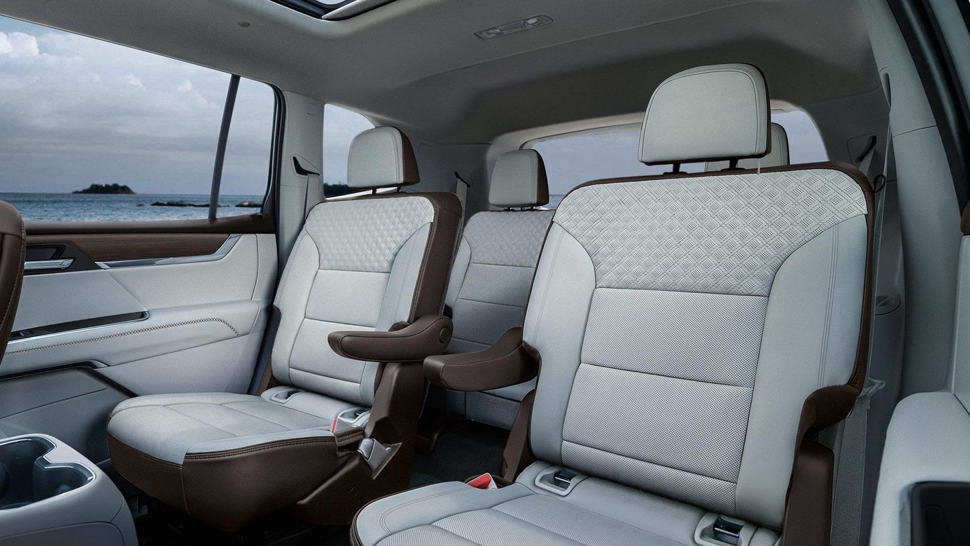 Second row seats inside a GMC Acadia with a view of a lake through the window