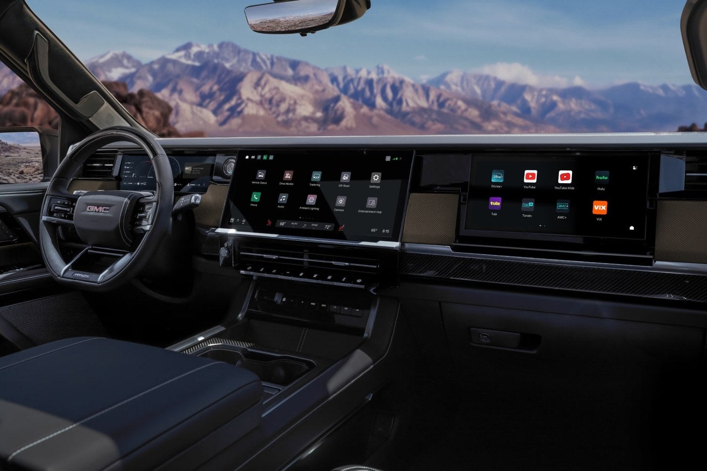 Wide infotainment screen and dashboard inside a GMC Sierra 1500 with mountains in view