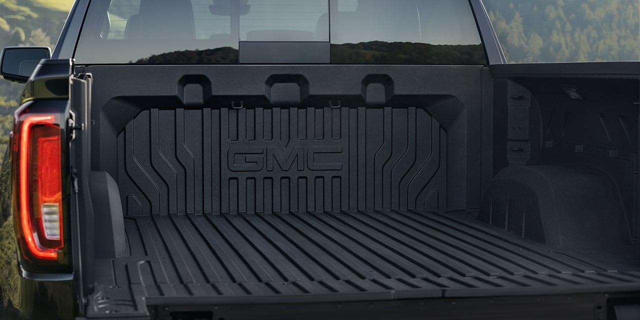 Open bed of a GMC Sierra 1500 showing the molded floor and tail lights