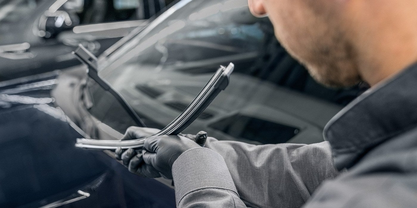 Technician inspecting a windshield wiper blade on a GMC vehicle