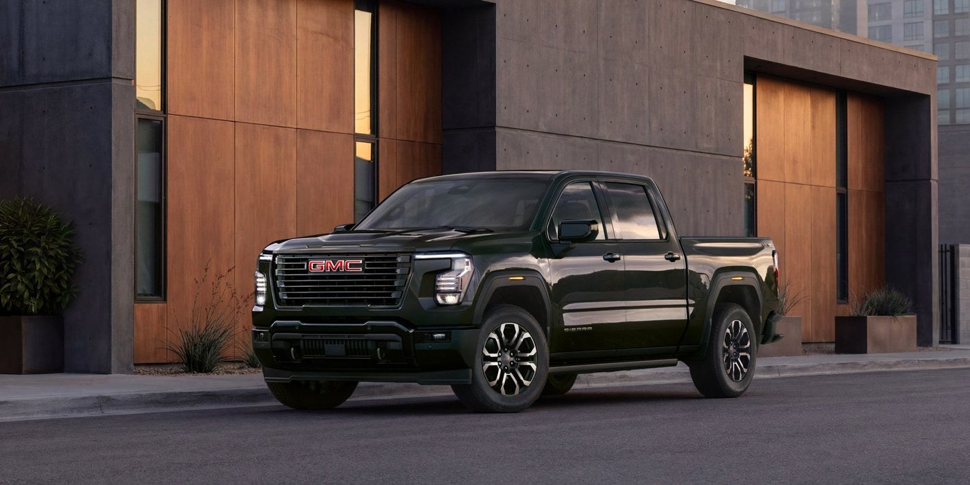 Dark GMC Sierra 1500 parked on a street in front of a modern building