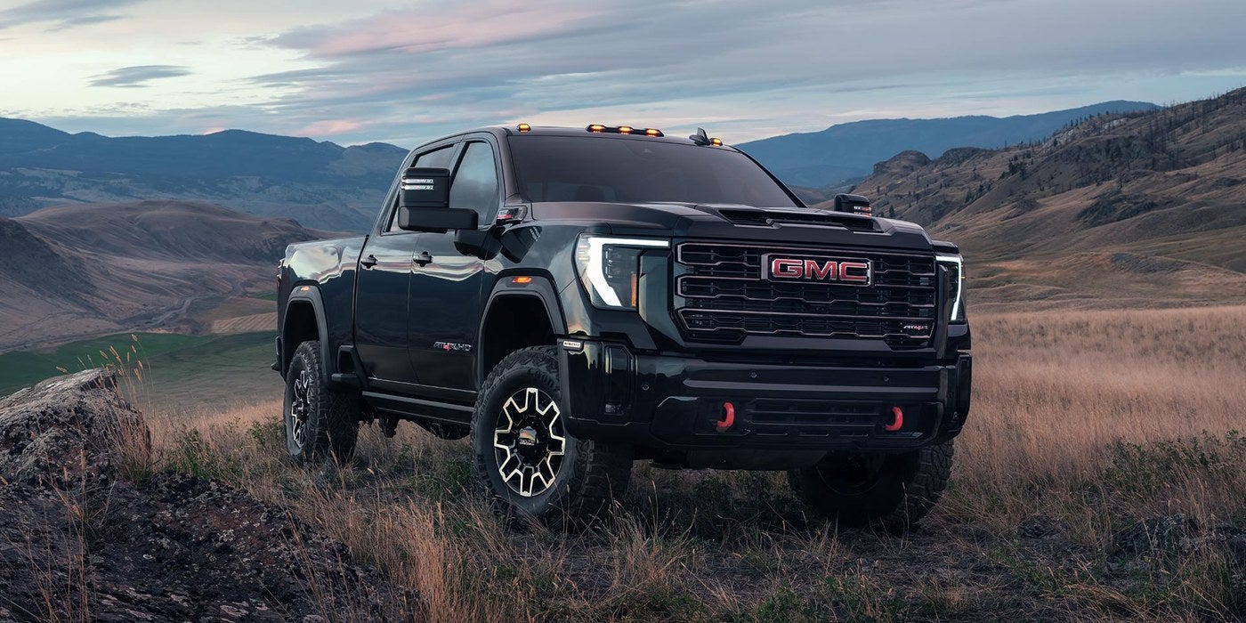 Black GMC Sierra HD pickup parked in an open grassy valley