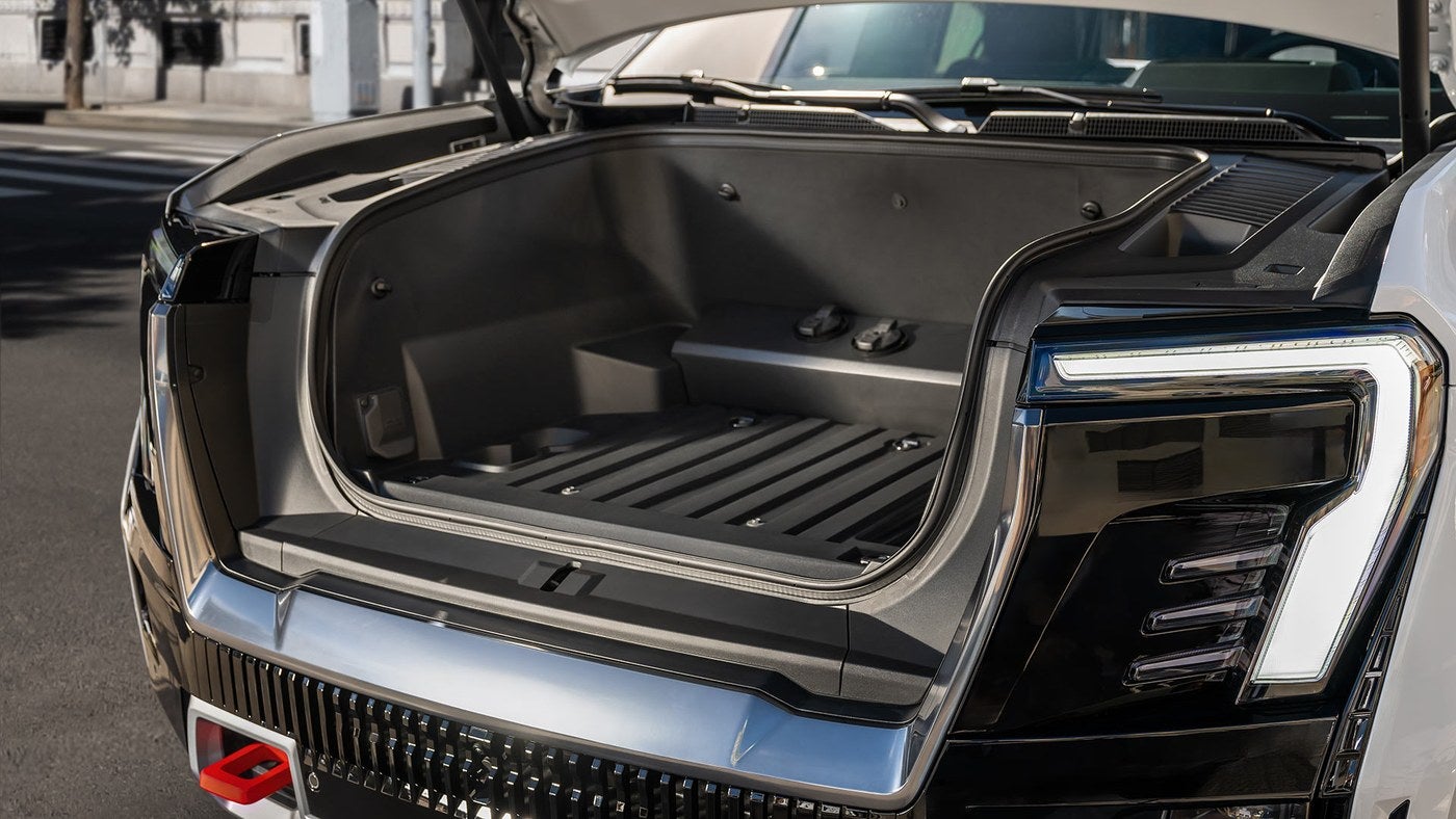 GMC Sierra EV with the power open front trunk lifted showing the storage area