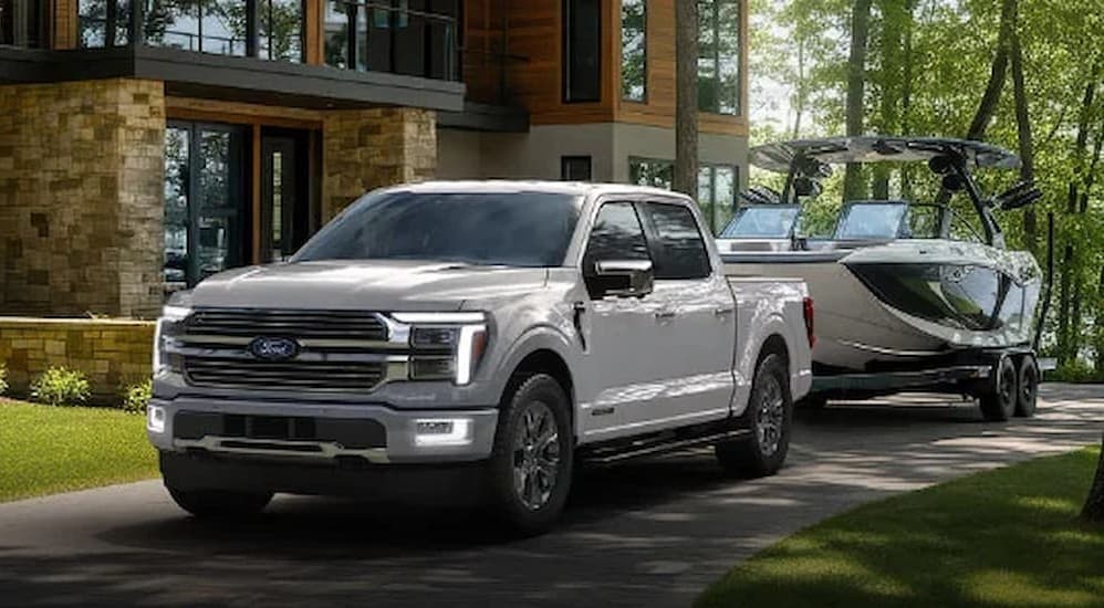 A white 2026 Ford F-150 towing a boat.