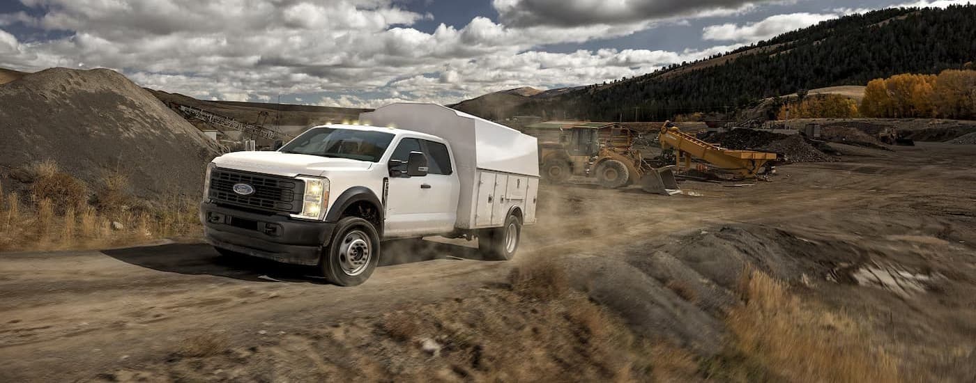 A white 2026 Ford F-350 driving on a dirt road.