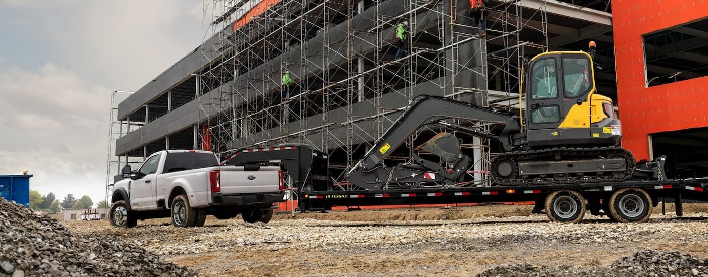 A white 2026 Ford F-450 towing a trailer.