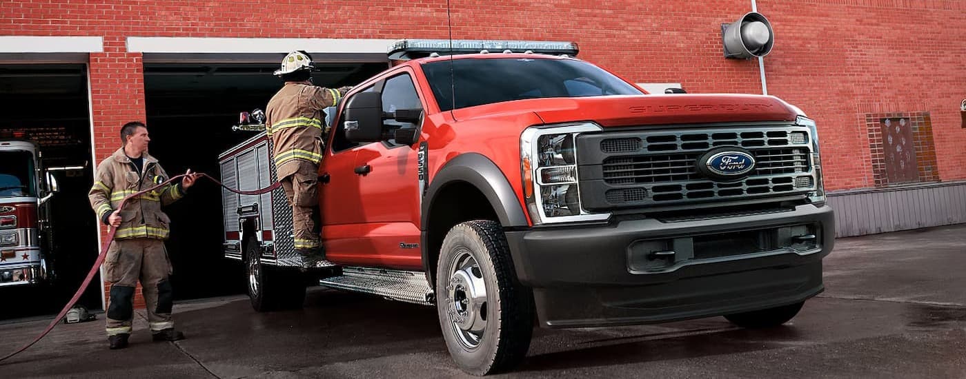 A red 2026 Ford F-550 parked at a fire station.