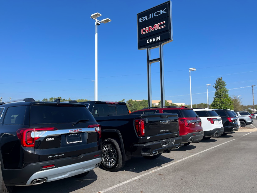Lineup of GMC SUVs and trucks parked under the Crain Buick GMC sign in Conway, Arkansas
