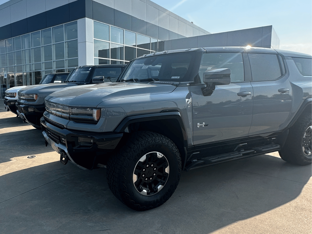 Front view of multiple 2026 GMC Hummer EV trucks lined up outside Crain Buick GMC in Conway, Arkansas, featuring the 3X trim in gray matte finish.