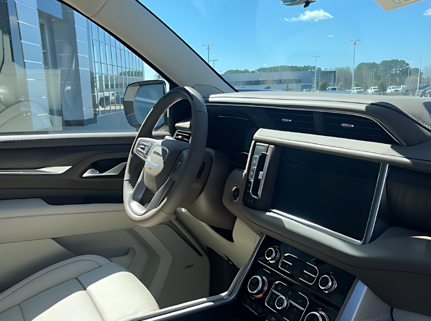 Interior view of a GMC SUV showing the steering wheel, dashboard, and touchscreen at Crain Buick GMC in Conway, Arkansas