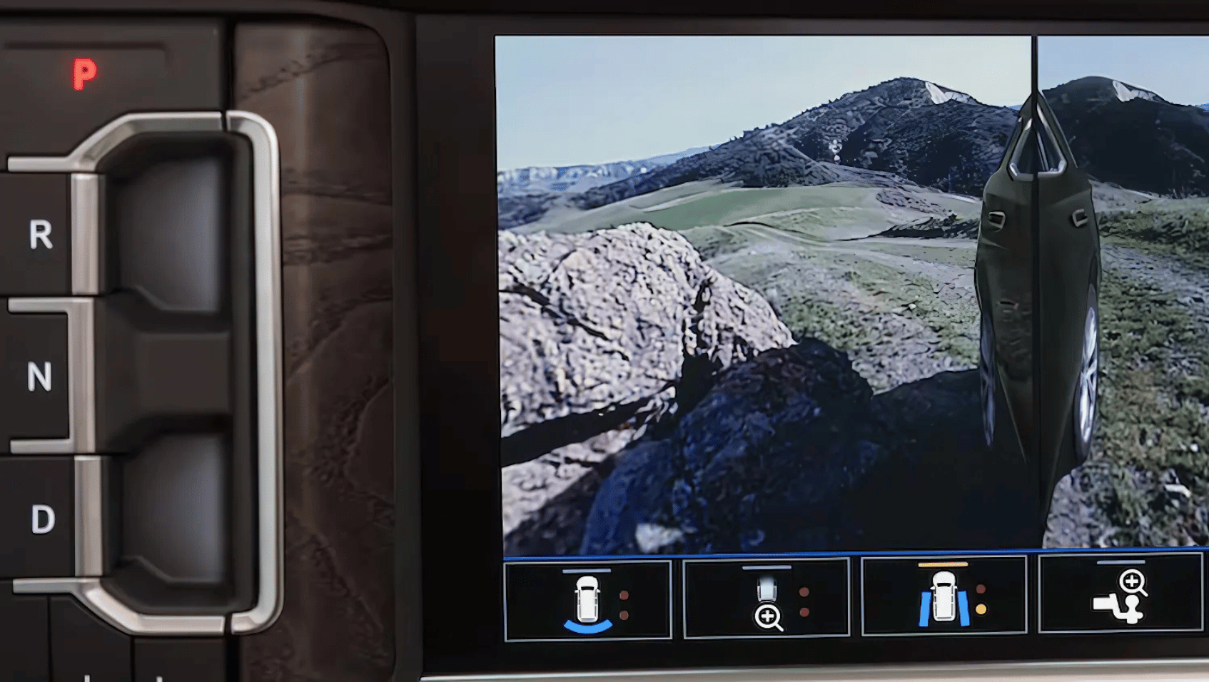 Close-up of the 2025 GMC Yukon’s ProGrade Trailering System with split-view cameras and drive selector for towing terrain