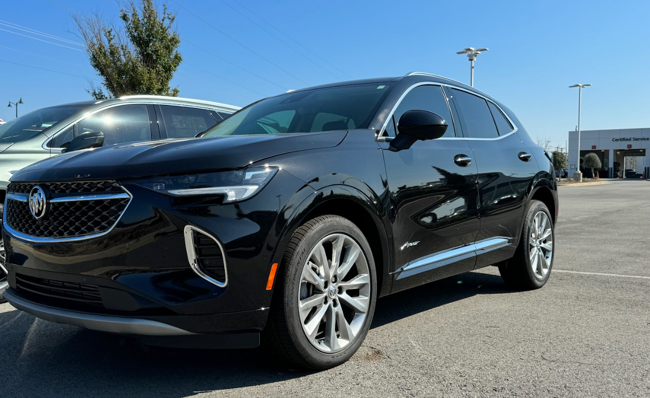 Glossy black 2024 Buick Envision Avenir SUV parked at Crain Buick GMC dealership in Conway.