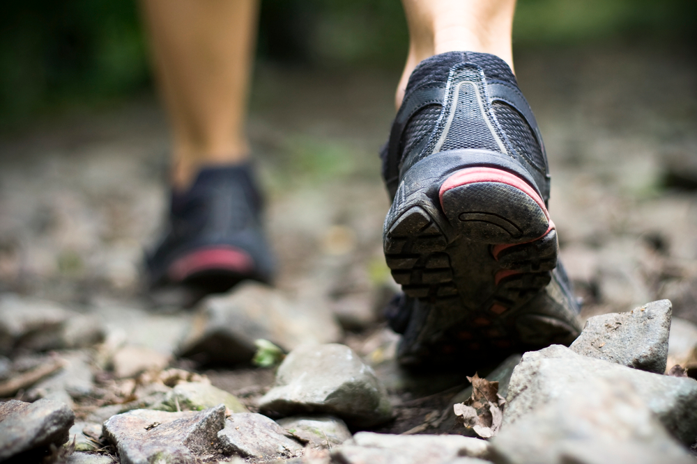 close up of hiking shoes of a person walking on rocks