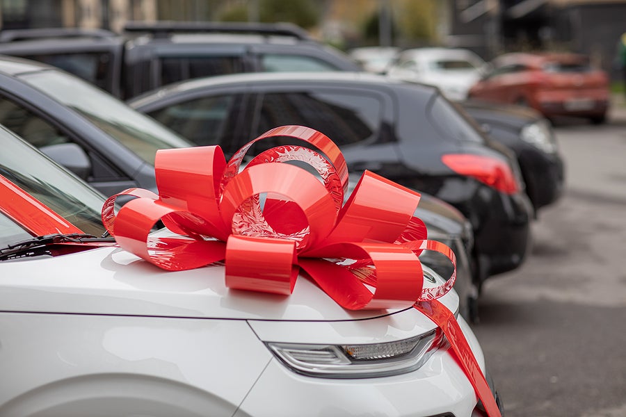 A White Car With A Big, Red Bow On The Hood