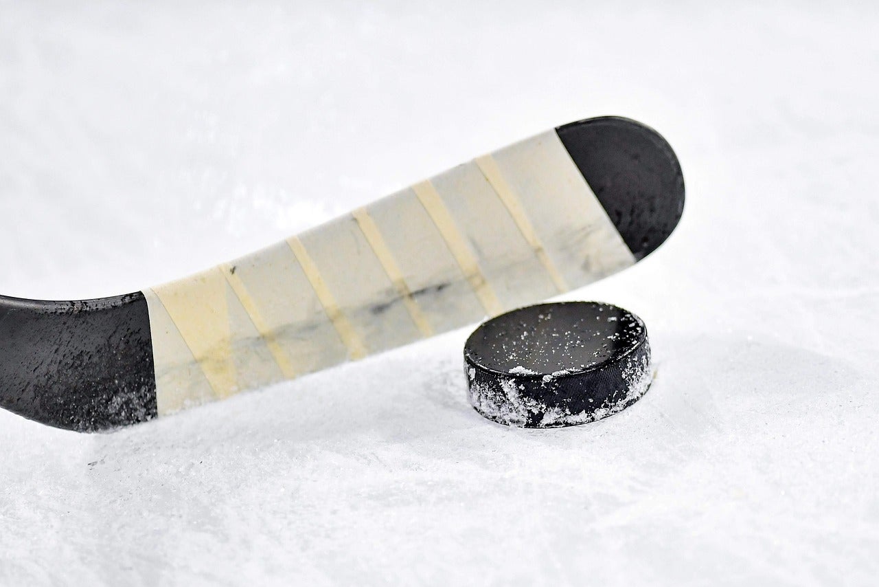 Close-up of a hockey puck and stick on the ice, representing local sports in North Little Rock, Arkansas