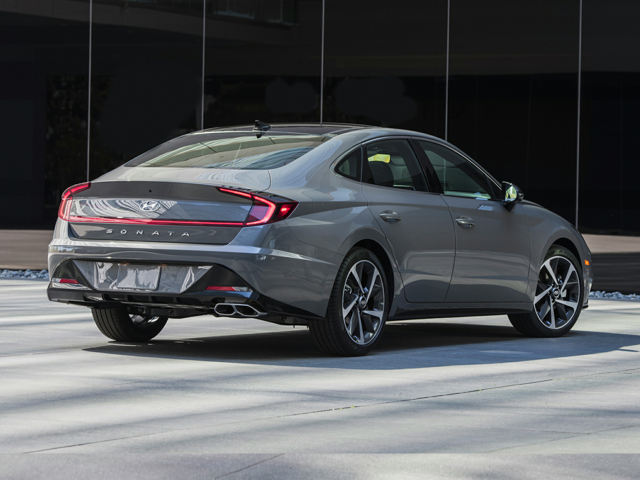 Rear view of a gray 2023 Hyundai Sonata sedan parked outside a modern glass building