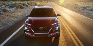 A red 2021 Hyundai Kona being driven on the highway. | Hyundai dealer in Little Rock, AR.
