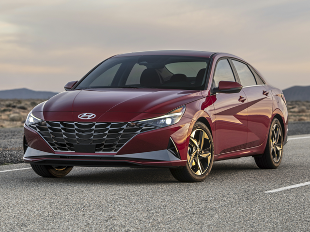 A red Hyundai Elantra parked on an open road at sunset, symbolizing safe driving with well-maintained brakes