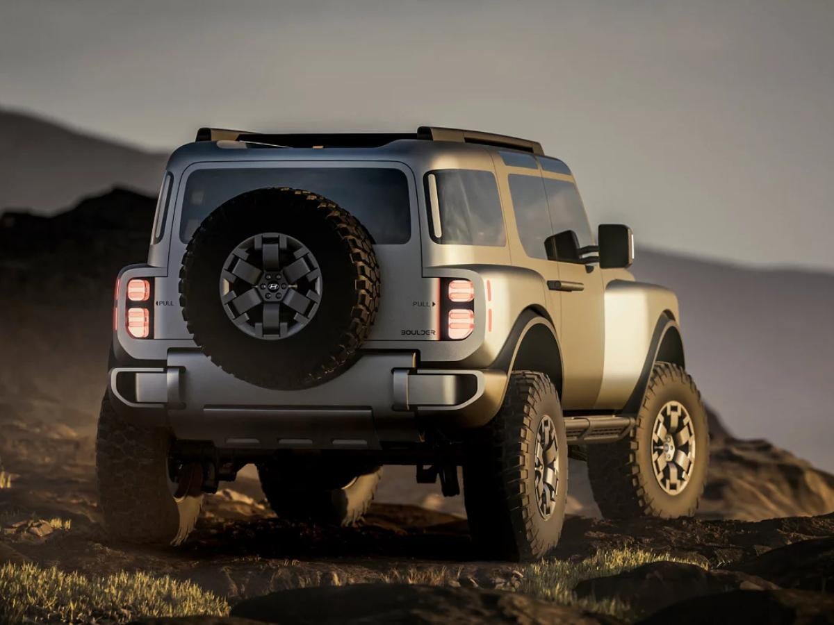 Hyundai Boulder concept SUV with rugged off-road tires and a rear-mounted spare, driving on rocky terrain near North Little Rock, AR