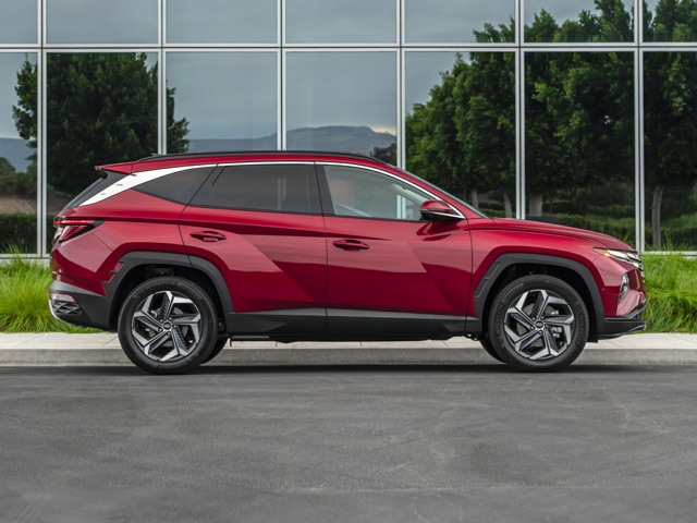 Profile view of a dark red 2023 Hyundai Tucson parked in front of a building. | Hyundai dealer in Fort Smith, AR.