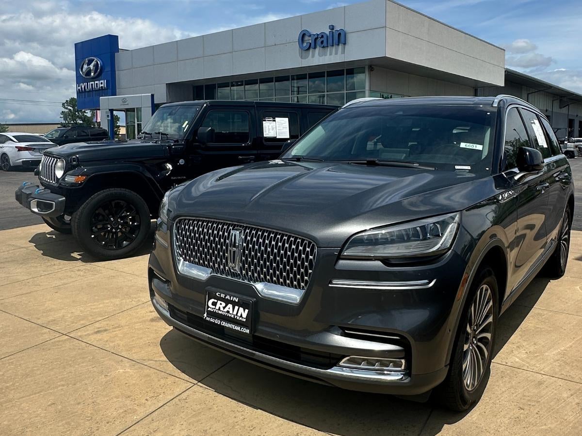A Lincoln SUV and a black Jeep parked outside Crain Hyundai of Fort Smith, representing the variety of vehicles customers can sell or trade through the Crain Buys Cars program.
