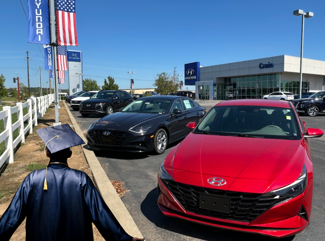 Hyundai dealership lot with a red Elantra and a graduate in a cap and gown