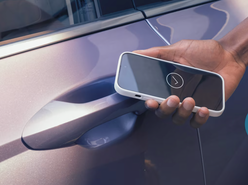 A person unlocking a Hyundai vehicle using a smartphone with Hyundai Digital Key 2 technology, demonstrating touchless vehicle access.