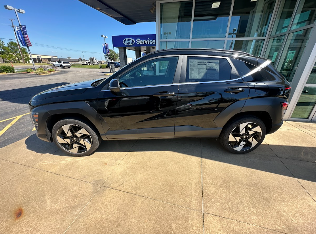 A black Hyundai SUV parked outside Crain Hyundai of Fort Smith, perfect for back-to-school shopping and commuting.