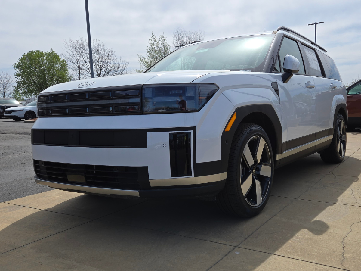 Front-side view of a white 2024 Hyundai Santa Fe SUV on the lot at Crain Hyundai of Fort Smith, showcasing its bold new design, LED lighting, and modernized body styling.