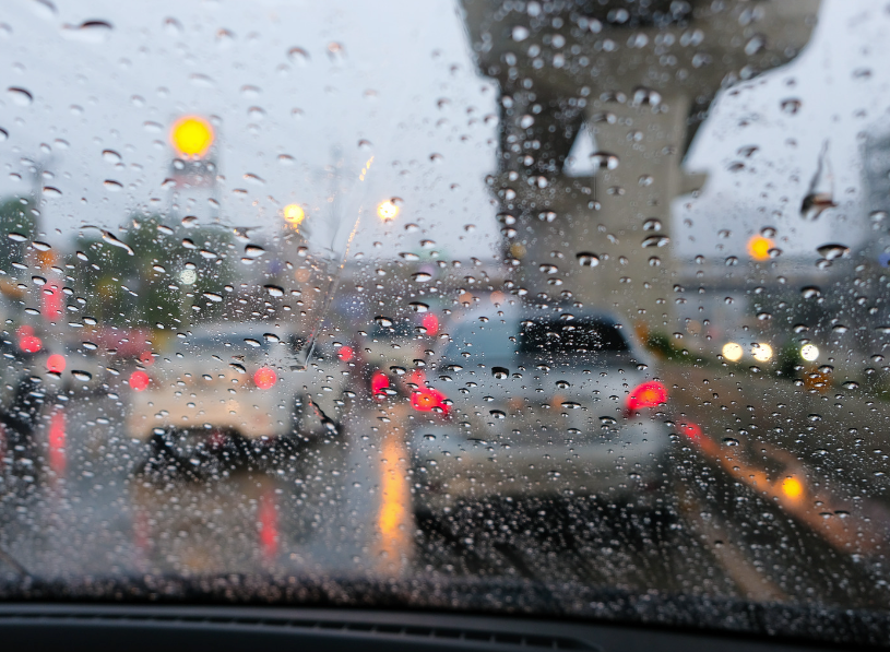 Rain-covered windshield looking out at Fort Smith traffic on a stormy day