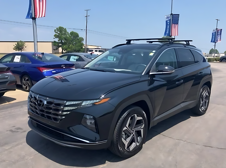 A black Hyundai SUV parked on the lot at Crain Hyundai of Fort Smith, surrounded by other certified used Hyundai vehicles and American flag banners.