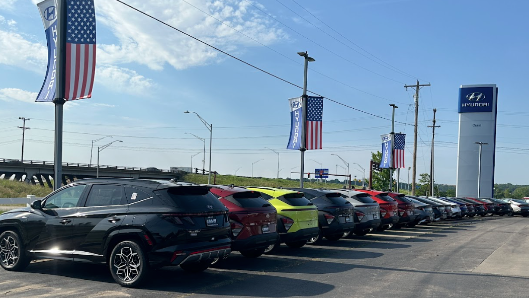 Hyundai SUVs lined up in a dealership lot with flags and signage