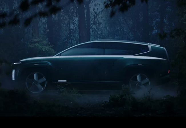 Silhouetted Hyundai Ioniq electric concept SUV in a misty forest at night