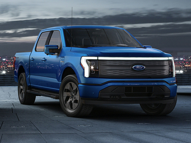 Front view of a blue 2023 Ford F-150 Lightning parked with dark cloudy skies overhead. | Ford dealer in Little Rock, AR | Crain Ford of Little Rock
