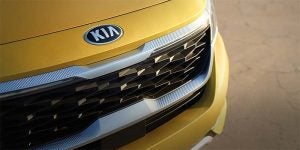 Close view of the grille area of a golden yellow 2021 Kia Seltos. | Kia dealer in Sherwood, AR.